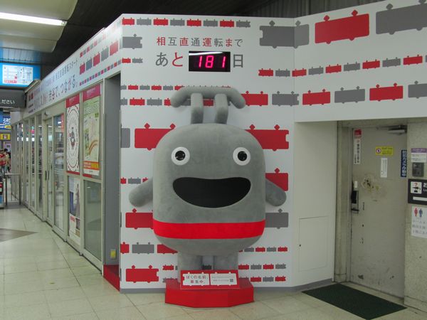 渋谷駅に設置された直通運転のカウントダウンボードと新キャラクターのぬいぐるみ。ぬいぐるみは左側の空間から中に入って口から顔を出すこともでき、お子様たちに人気。