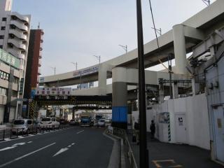 駅前交番の前から第一京浜をまたぐ空港線の高架橋を見る。3階の下り線でも架線柱の設置が始まった。