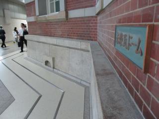 壁面にある「赤煉瓦ドーム」の銘板。床面は免震化に対応して伸縮継目が設置された。