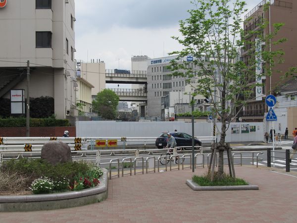 この先は横浜駅西口駅ビル再開発の事業用地となっている。奥の二重高架は首都高速2号三ッ沢線。その下には拡幅された横須賀線ホームを覆う骨組みが見える。